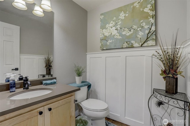 22506 SE 277th Pl, Maple Valley, WA 98038 - half bathroom with vanity, toilet, a decorative wall, and wainscoting