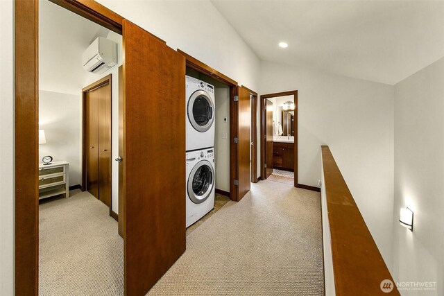 2648 NW 57th St Unit A, Seattle, WA 98107 - laundry area with estacked washer and dryer, a wall mounted air conditioner, light carpet, and baseboards