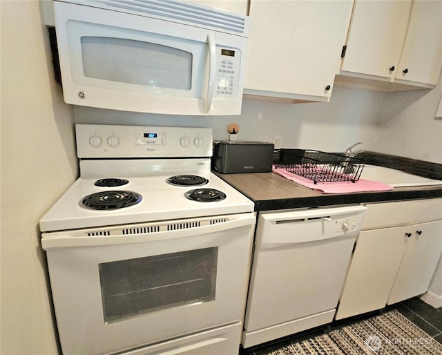 7924 212th St SW Unit 104, Edmonds, WA 98026 - kitchen with white appliances, dark countertops, white cabinetry, and dark tile patterned floors