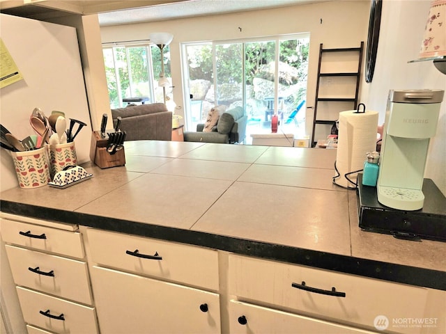 7924 212th St SW Unit 104, Edmonds, WA 98026 - kitchen with white cabinets, healthy amount of natural light, and open floor plan