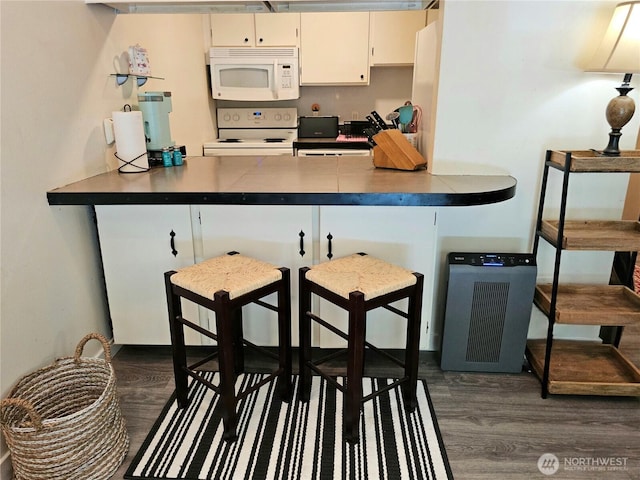 7924 212th St SW Unit 104, Edmonds, WA 98026 - kitchen with white appliances, dark wood-style flooring, and a peninsula