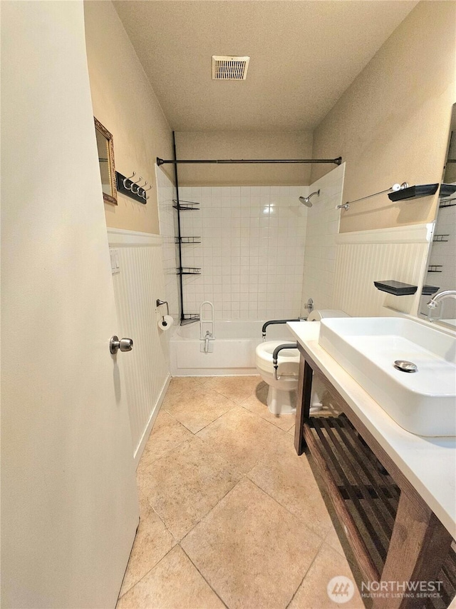 7924 212th St SW Unit 104, Edmonds, WA 98026 - bathroom featuring shower / bathtub combination, tile patterned floors, vanity, and wainscoting
