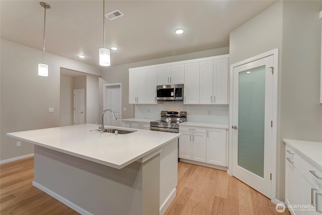 18226 37th Ave E, Tacoma, WA 98446 - kitchen featuring stainless steel appliances, a sink, light wood-style flooring, white cabinets, and recessed lighting