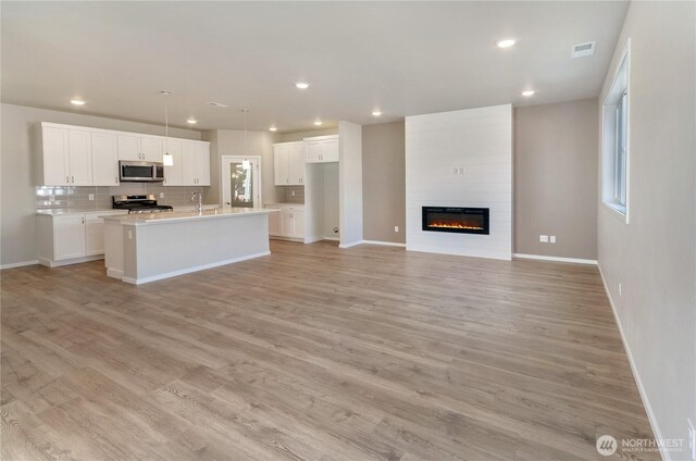 18226 37th Ave E, Tacoma, WA 98446 - kitchen with appliances with stainless steel finishes, an island with sink, baseboards, and recessed lighting