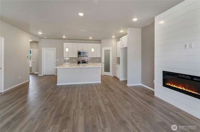 18226 37th Ave E, Tacoma, WA 98446 - kitchen with stainless steel appliances, dark wood finished floors, white cabinetry, a fireplace, and recessed lighting