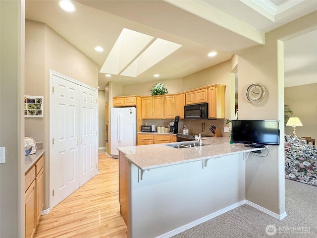 40 Cascadia Loop, Sequim, WA 98382 - kitchen featuring black microwave, freestanding refrigerator, a sink, light brown cabinets, and a peninsula
