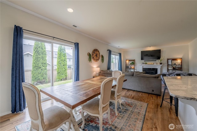 7615 14th St SE, Lake Stevens, WA 98258 - dining area featuring ornamental molding, a fireplace, light wood-style flooring, and recessed lighting