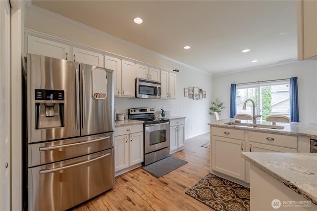 7615 14th St SE, Lake Stevens, WA 98258 - kitchen with appliances with stainless steel finishes, a sink, crown molding, white cabinets, and light wood finished floors