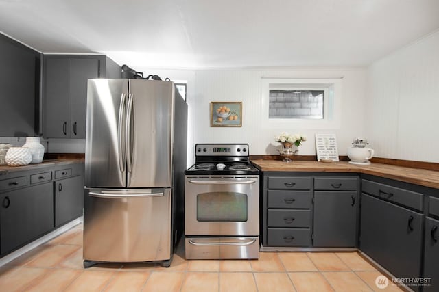 2560 Gilman Dr W, Seattle, WA 98119 - kitchen with appliances with stainless steel finishes, wood counters, light tile patterned floors, and gray cabinetry