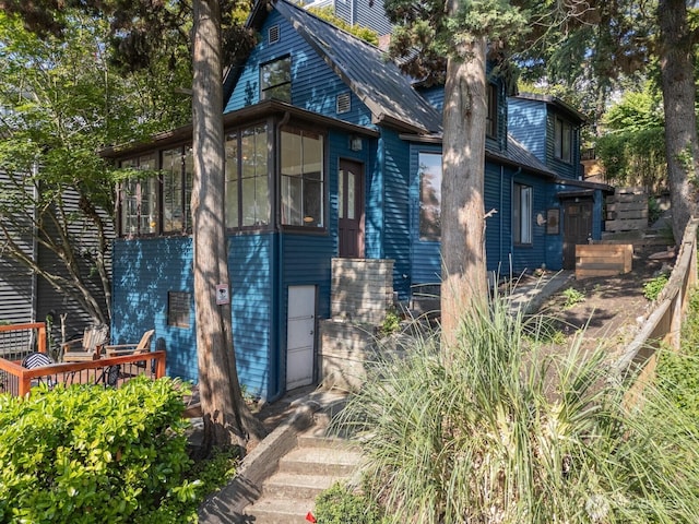 2560 Gilman Dr W, Seattle, WA 98119 - view of front of home with a sunroom, a wooden deck, and a chimney