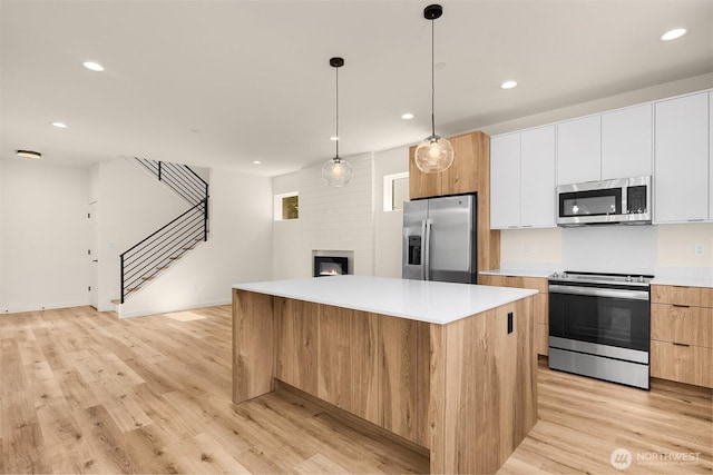 118 4th Ave S, Algona, WA 98001 - kitchen featuring appliances with stainless steel finishes, modern cabinets, a center island, open floor plan, and light wood finished floors