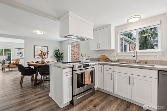 1022 N Anderson St, Tacoma, WA 98406 - kitchen featuring stainless steel appliances, a peninsula, white cabinets, dark wood-style floors, and custom range hood