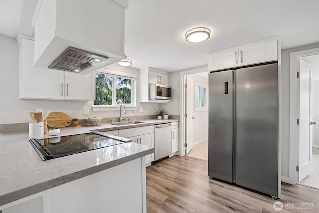1022 N Anderson St, Tacoma, WA 98406 - kitchen with stainless steel appliances, premium range hood, white cabinets, and light wood finished floors