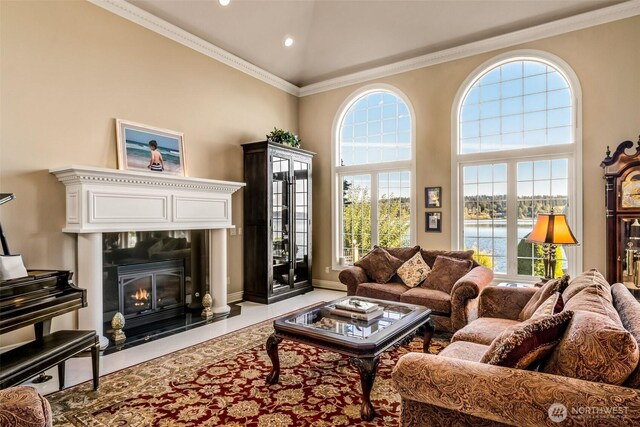 17765 Beach Dr NE, Lake Forest Park, WA 98155 - living area with a water view, plenty of natural light, ornamental molding, a towering ceiling, and a glass covered fireplace
