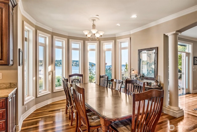 17765 Beach Dr NE, Lake Forest Park, WA 98155 - dining space with decorative columns, wood finished floors, a chandelier, crown molding, and baseboards