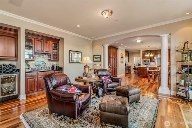 17765 Beach Dr NE, Lake Forest Park, WA 98155 - living area with ornate columns, wine cooler, bar, light wood finished floors, and ornamental molding