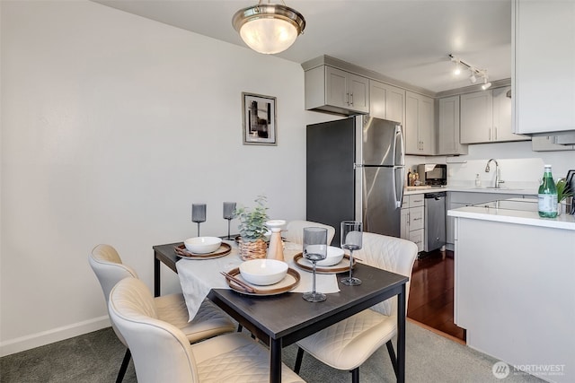3814 11th Ave W Apt 23, Seattle, WA 98119 - carpeted dining space featuring a sink, baseboards, and track lighting