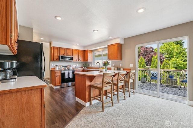 26820 NE 163rd St, Duvall, WA 98019 - kitchen featuring appliances with stainless steel finishes, light countertops, brown cabinetry, recessed lighting, and a breakfast bar