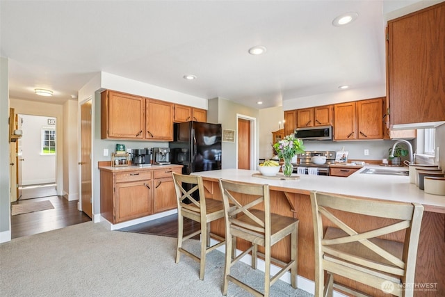 26820 NE 163rd St, Duvall, WA 98019 - kitchen featuring appliances with stainless steel finishes, a sink, a peninsula, dark carpet, and light countertops