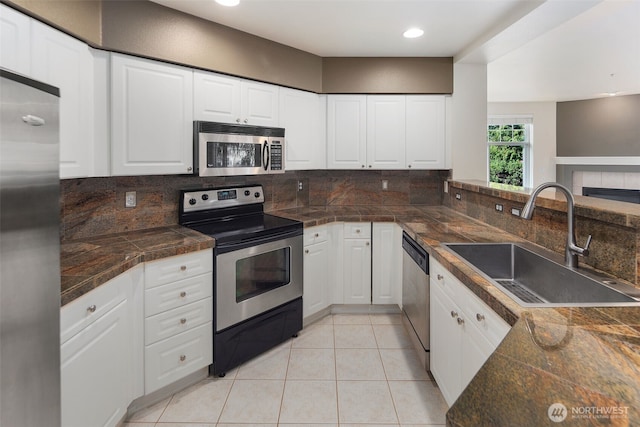 2220 132nd Ave SE Unit A220, Bellevue, WA 98005 - kitchen featuring appliances with stainless steel finishes, a sink, tile countertops, backsplash, and white cabinets