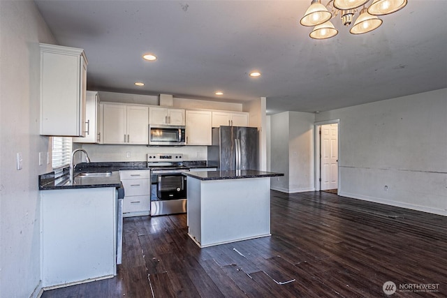 20007 17th Ave E, Spanaway, WA 98387 - kitchen with stainless steel appliances, a sink, dark wood-type flooring, a kitchen island, and white cabinetry