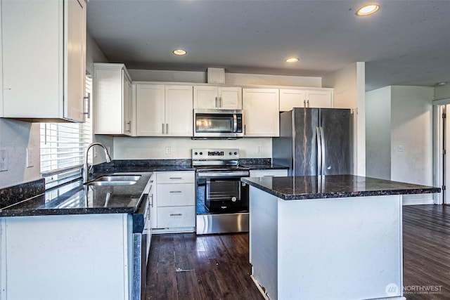 20007 17th Ave E, Spanaway, WA 98387 - kitchen featuring appliances with stainless steel finishes, a sink, dark wood-style flooring, a center island, and white cabinets