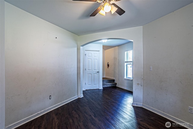 20007 17th Ave E, Spanaway, WA 98387 - unfurnished room featuring arched walkways, wood finished floors, ceiling fan, and baseboards