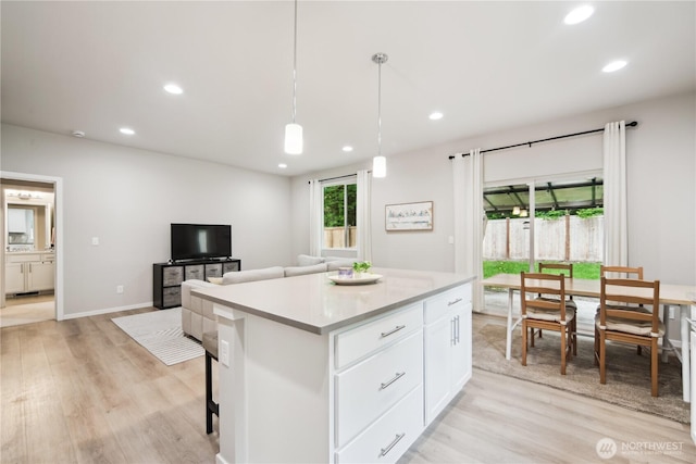4305 23rd Ct NE, Olympia, WA 98516 - kitchen with light wood finished floors, recessed lighting, white cabinetry, a kitchen island, and decorative light fixtures