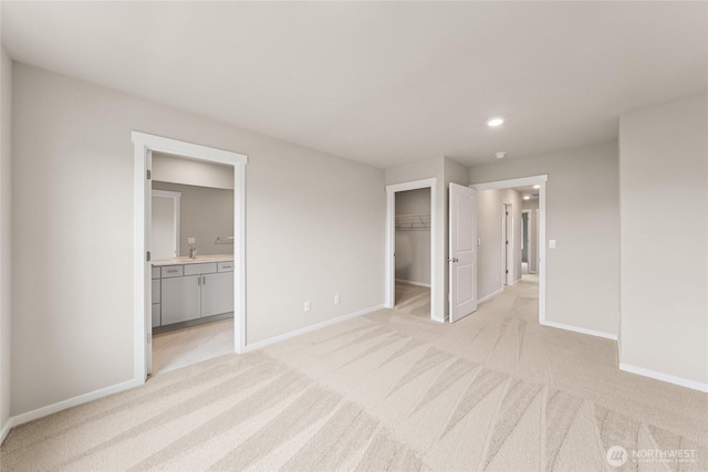 14830 203rd Ave E Unit 684, Bonney Lake, WA 98391 - unfurnished bedroom with baseboards, light carpet, a sink, ensuite bathroom, and a walk in closet