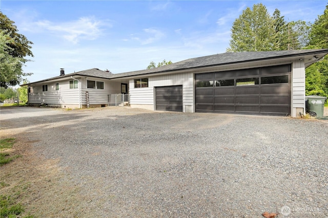 11012 36th St E, Edgewood, WA 98372 - view of front facade featuring a garage and gravel driveway