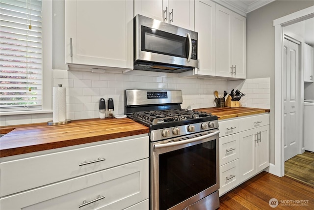 11012 36th St E, Edgewood, WA 98372 - kitchen featuring butcher block counters, stainless steel appliances, white cabinets, crown molding, and dark wood-style flooring