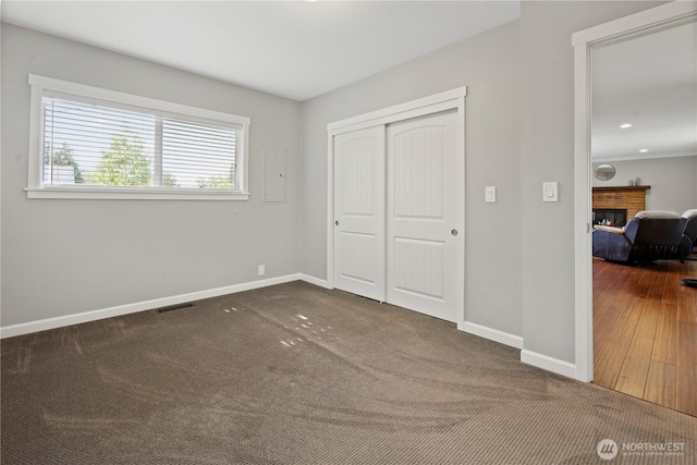 11012 36th St E, Edgewood, WA 98372 - unfurnished bedroom with a glass covered fireplace, a closet, and carpet floors