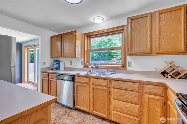 2779 Maple Tree Ln, Camano Island, WA 98282 - kitchen featuring appliances with stainless steel finishes, a sink, light countertops, and a textured ceiling