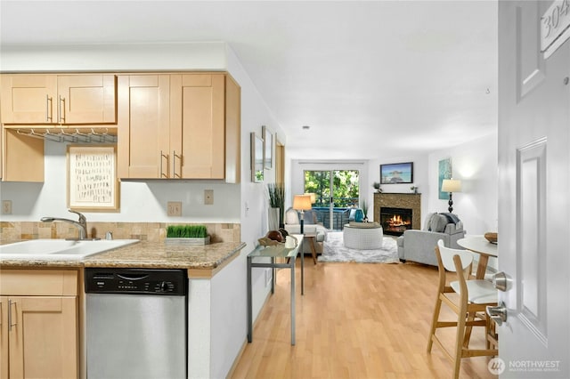 6970 California Ave SW Unit B304, Seattle, WA 98136 - kitchen with dishwasher, light brown cabinets, light wood-style floors, a lit fireplace, and open floor plan