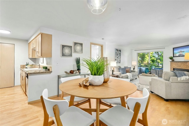 6970 California Ave SW Unit B304, Seattle, WA 98136 - dining space featuring light wood-style flooring and a fireplace