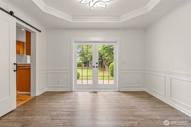 27701 NE 145th Pl, Duvall, WA 98019 - empty room with a raised ceiling, wood finished floors, ornamental molding, a barn door, and french doors