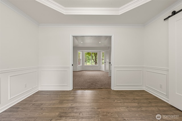 27701 NE 145th Pl, Duvall, WA 98019 - empty room with a barn door, ornamental molding, wood finished floors, a tray ceiling, and wainscoting