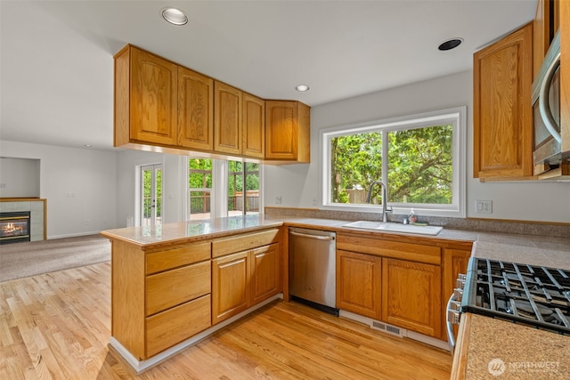 27701 NE 145th Pl, Duvall, WA 98019 - kitchen with appliances with stainless steel finishes, a peninsula, a tile fireplace, light countertops, and recessed lighting