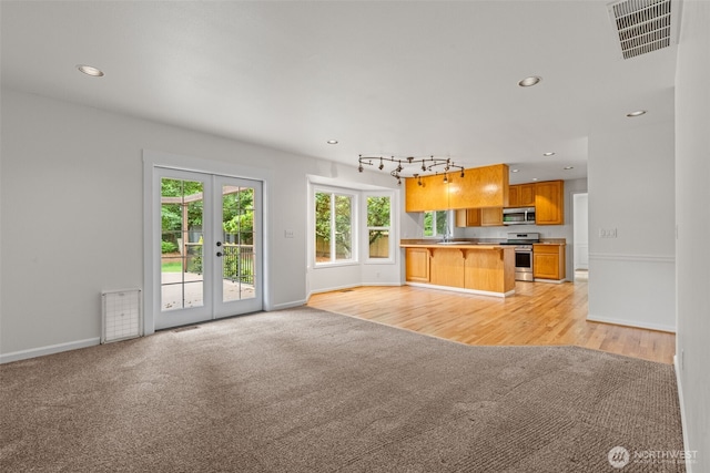 27701 NE 145th Pl, Duvall, WA 98019 - unfurnished living room featuring light carpet, french doors, recessed lighting, and light wood-style flooring