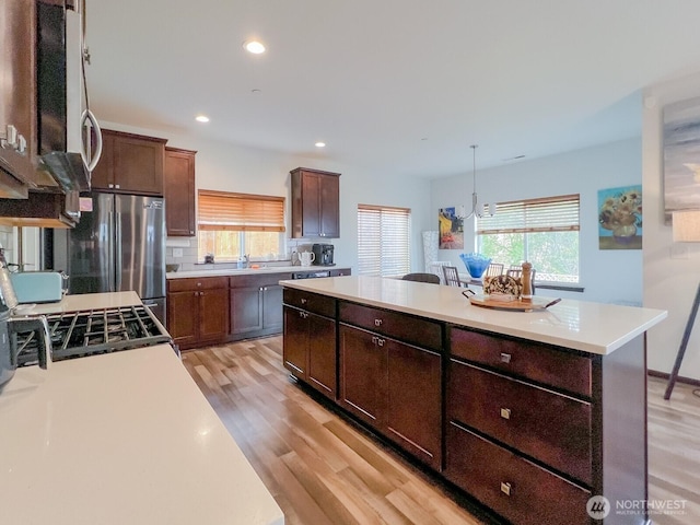 2744 S 120th Pl, Seattle, WA 98168 - kitchen featuring plenty of natural light, a center island, light countertops, light wood finished floors, and recessed lighting