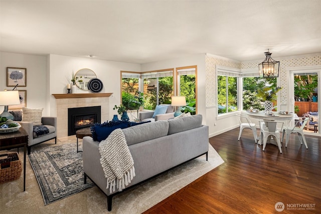 23976 SE 40th Pl, Sammamish, WA 98029 - living area featuring a tiled fireplace, dark wood-style floors, a chandelier, and baseboards