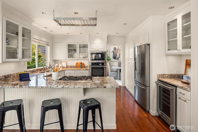 23976 SE 40th Pl, Sammamish, WA 98029 - kitchen featuring appliances with stainless steel finishes, wine cooler, a peninsula, dark wood-type flooring, and white cabinetry