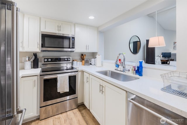 130 SW 116th St Unit F32, Seattle, WA 98146 - kitchen featuring stainless steel appliances, a sink, recessed lighting, light countertops, and white cabinets
