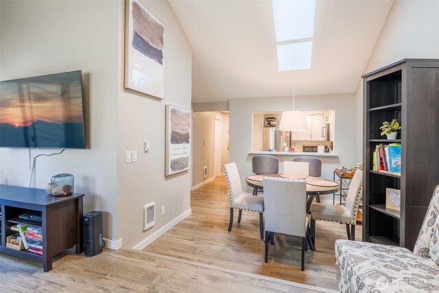 130 SW 116th St Unit F32, Seattle, WA 98146 - dining space featuring a skylight, wood finished floors, vaulted ceiling, and baseboards