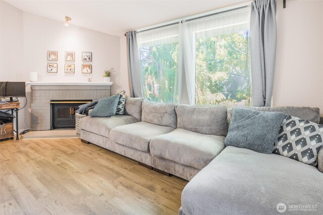 130 SW 116th St Unit F32, Seattle, WA 98146 - living area with light wood-style flooring and a brick fireplace