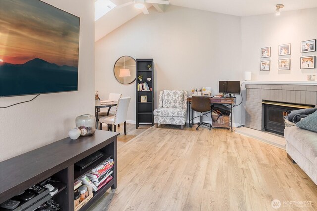 130 SW 116th St Unit F32, Seattle, WA 98146 - living room with wood finished floors, ceiling fan, vaulted ceiling, and a brick fireplace