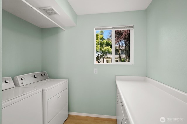 4206 SE 1st Pl, Renton, WA 98059 - laundry area with washer and dryer, light wood finished floors, cabinet space, and baseboards