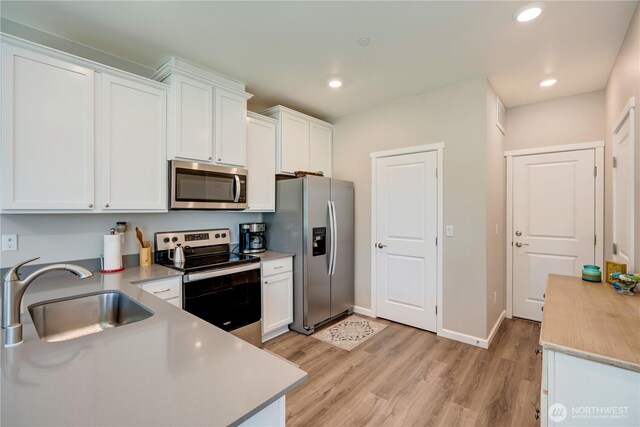 8713 E Gilman Ave, Arlington, WA 98223 - kitchen featuring appliances with stainless steel finishes, a sink, white cabinetry, and recessed lighting