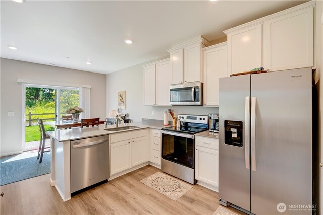 8713 E Gilman Ave, Arlington, WA 98223 - kitchen with appliances with stainless steel finishes, light wood-type flooring, white cabinets, and recessed lighting