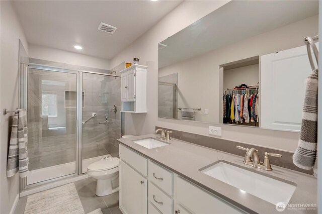 8713 E Gilman Ave, Arlington, WA 98223 - bathroom with double vanity, a shower stall, toilet, a walk in closet, and recessed lighting